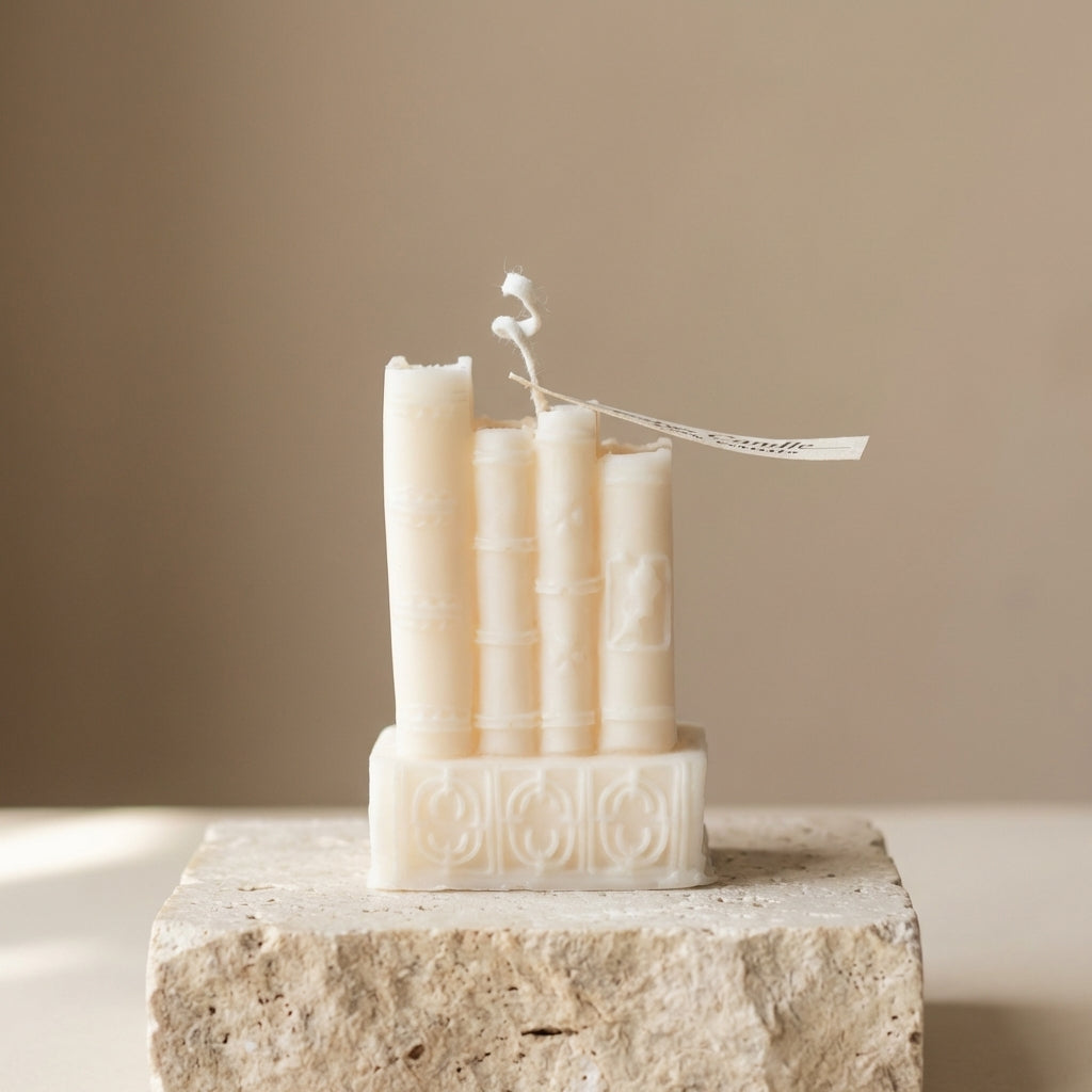 Close-up of a hand-poured soy wax vintage book stack candle highlighting its detailed, textured antique spines and embossed covers.