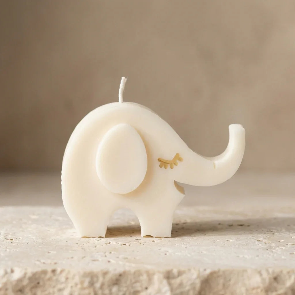 White elephant-shaped candle on a beige surface with a neutral background